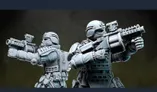 Two detailed miniatures from Anvil Industry's Special Forces range are positioned back-to-back, each holding futuristic firearms. The figures are clad in tactical armor with various pouches and equipment, showcasing a blend of sleek design and functionality. The miniatures are presented in a gray, unpainted finish, highlighting their intricate details and dynamic poses.