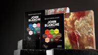 Two sets of John Blanche Masterclass paints are displayed, with Volume 3 on the left featuring a cool color palette, including shades like "Farewell" and "Shadow Thorn," and Volume 4 on the right showcasing warm tones such as "Emberowl" and "Blood Thorn." Both sets are presented in sleek black packaging with vibrant hexagonal labels indicating the paint colors. The background is dark, enhancing the visual impact of the paint sets.