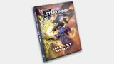 A book titled "Starfinder Galaxy Guide Second Edition" rests on a light surface. The cover features a detailed illustration of a futuristic scene. In the foreground, a humanoid figure in a high-tech suit with glowing elements stands on a platform or walkway, holding a weapon. The figure appears to be in a dynamic pose, possibly in combat or taking defensive action. Behind the figure, a large, complex, alien structure or creature with multiple tendrils and glowing sections dominates the scene. The background includes a starry sky with a planet visible in the distance. The spine of the book reads "Starfinder Galaxy Guide Second Edition." The logo "STARFINDER" is prominently displayed at the top of the cover in bold, futuristic lettering.