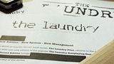 A close-up view of a printed document featuring the title "THE LAUNDRY" prominently displayed at the top, with a distressed font style. Below the title, the text indicates that it is based on the "LAUNDRY FILES" novels by Charles Stross, and mentions "System - New Management." The document appears to be part of promotional material for the latest edition of the Laundry RPG.