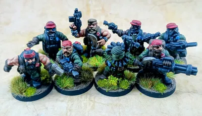A group of eight intricately detailed miniatures representing space dwarves in a jungle setting, each standing on circular bases adorned with tufts of grass. The figures are dressed in military-style attire, featuring green clothing and red caps, with various weapons including guns and a curved blade. Their expressions are fierce and determined, showcasing a blend of ruggedness and character typical of old-school metal miniatures.