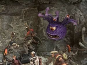 A collection of fantasy miniatures features several lizardmen, one wielding a shield and weapon, and another with a torch, set against a rocky backdrop. In the background, a large, purple creature with multiple eyes and a menacing expression looms, adding to the scene's fantastical atmosphere. A female character in dark robes stands nearby, while other figures in armor are partially visible, enhancing the sense of adventure.