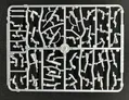 A plastic sprue featuring various components for miniature figures, including torsos, limbs, and heads, designed for 28mm scale modern civilians and post-apocalyptic survivors. The sprue showcases a variety of poses and accessories, including weapons, allowing for customization of the miniatures. The pieces are molded in a light gray plastic and are arranged in a grid pattern on a black background.