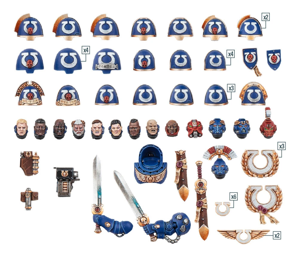 A collection of Ultramarine upgrade components is displayed, featuring various sculpted shoulder pads, helmets, and accessories in a blue and gold color scheme. The parts include multiple shoulder pads designed for different unit types, as well as heads, swords, and decorative elements like laurels and purity seals. Additionally, a transfer sheet with numerous decals for customization is included, showcasing campaign badges and Ultramarines Chapter icons.