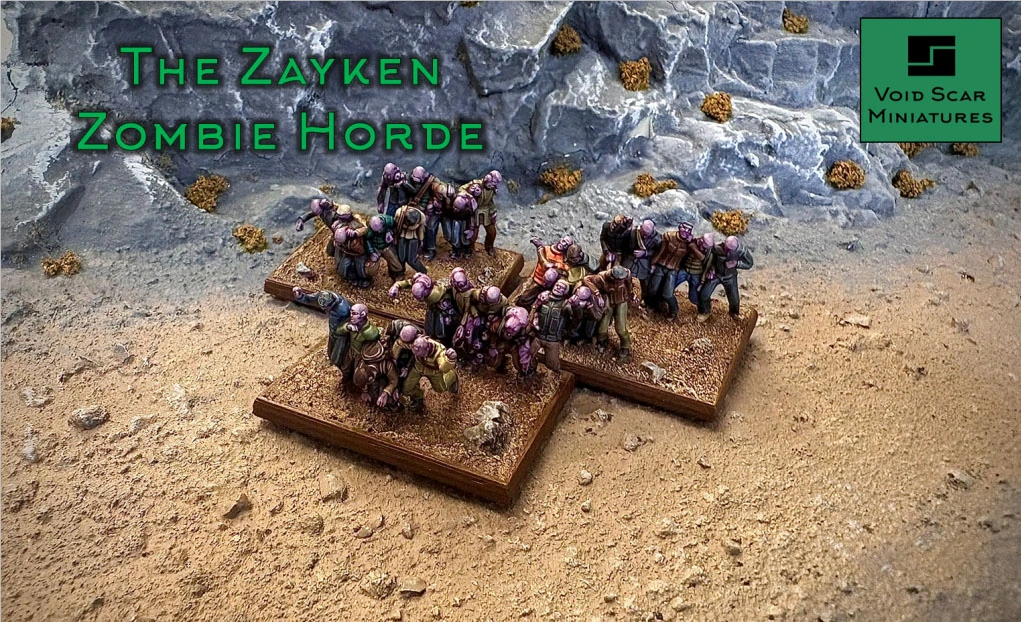 A group of Zayken miniatures representing a horde of zombies is displayed on two textured bases, set against a rocky backdrop. The zombies exhibit various poses, with some appearing hunched and others reaching forward, showcasing their grotesque features and tattered clothing. The scene is set on a sandy terrain, with scattered rocks and sparse vegetation, emphasizing the desolate environment of the sci-fi wargame.