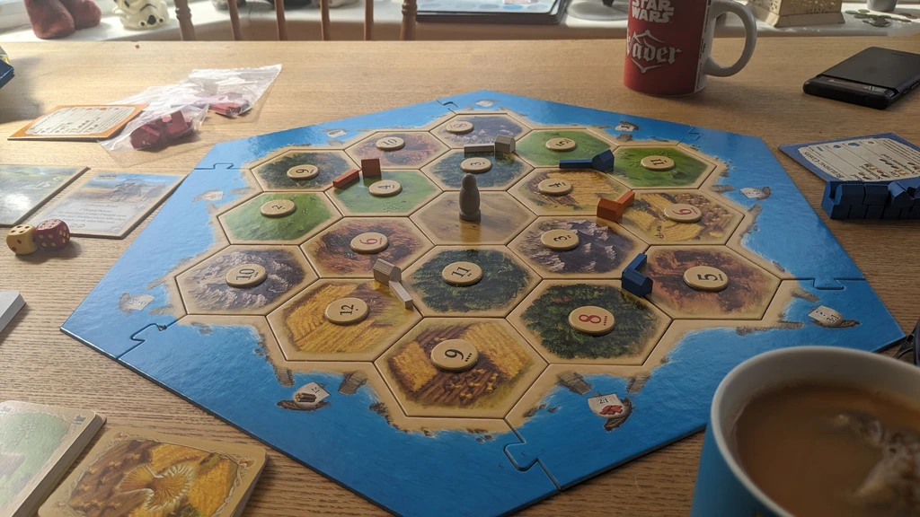 The Catan board laid out as  advised for beginners. On a dining table with tea