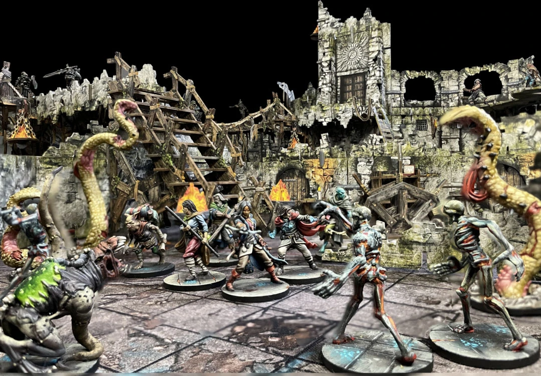A dynamic scene features a group of detailed miniatures engaged in battle within a ruined, multi-level terrain setting. The backdrop includes crumbling stone walls, wooden scaffolding, and flickering flames, creating a dramatic atmosphere. Among the miniatures are various characters, including a humanoid warrior, a cloaked figure, and a monstrous creature, all poised for action against a new threat.