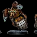 A detailed miniature of a robotic character features a round body with a metallic, silver barrel-like base and a prominent, circular golden core. It has two mechanical arms, one equipped with a green-tipped weapon and the other with a series of intricate gears and glowing green eyes. The figure stands on a textured black base, showcasing a weathered, industrial aesthetic with hints of rust and wear.
