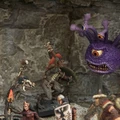 A collection of fantasy miniatures features several lizardmen, one wielding a shield and weapon, and another with a torch, set against a rocky backdrop. In the background, a large, purple creature with multiple eyes and a menacing expression looms, adding to the scene's fantastical atmosphere. A female character in dark robes stands nearby, while other figures in armor are partially visible, enhancing the sense of adventure.