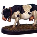 A detailed miniature of a black and white cow stands on a textured base resembling grass and dirt. The cow is depicted with a collar and bell around its neck, showcasing realistic features such as its distinct markings and posture. This figure adds a whimsical touch, fitting for a fantasy tavern setting.