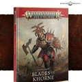 A striking cover for the "Blades of Khorne" Battletome features a powerful warrior, the Deathbringer, clad in menacing armor and wielding a massive axe and a spiked shield. The background depicts a chaotic battlefield with skulls and war machines, emphasizing the theme of bloodshed and chaos. The title "BLADES OF KHORNE" is prominently displayed at the bottom, with the Warhammer logo at the top.