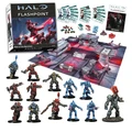 A boxed set for "Halo: Flashpoint" titled "Rise of the Banished" is prominently displayed, featuring a vibrant gaming board with red and gray terrain elements. Surrounding the box are various miniatures, including armored figures and alien characters, showcasing a mix of colors like blue, red, and green. Additional components such as dice, tokens, and a rulebook titled "Defiance" are also visible, enhancing the game's playability.
