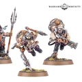 Three Kharadron Overlords miniatures are displayed, showcasing their unique designs. On the left, a dwarf holds a trident and wears a detailed nullsuit, while the central figure, appearing dynamic, is equipped with a spear and a large backpack. The rightmost figure wields a firearm and has a rugged appearance, all standing on textured bases with tufts of grass.