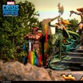 A detailed scene features four miniatures from the Marvel Crisis Protocol game, set against a backdrop of lush greenery and rocky terrain. Prominently displayed are Amora the Enchantress, wearing a green outfit and flowing hair, and Skurge the Executioner, who stands with a sword and a colorful, rainbow-like shield. In the background, additional characters and elements hint at the Asgardian theme, enhancing the vibrant and dynamic atmosphere of the tableau.