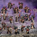 A collection of detailed miniature figures from the Black Templar faction of Warhammer 40,000 is displayed against a dark, rocky backdrop. The figures include various characters such as the Emperor’s Champion, Bladeguard Veterans, and Sword Brethren, all adorned in black and red armor with intricate details. Some figures wield swords and ranged weapons, showcasing a mix of melee and ranged combat capabilities, while the overall composition emphasizes their readiness for battle.
