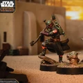 A detailed miniature of Boba Fett stands in a dynamic pose, wielding a weapon, with his iconic green and red armor featuring a distinctive emblem on his shoulder. Beside him, Grogu, also known as "The Child," is depicted with large ears and a curious expression, standing on a small base. The background features a sandy terrain with hints of structures, creating a Star Wars-themed environment.