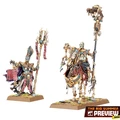 A pair of undead miniatures from the Old World are featured, showcasing a Royal Herald on foot and a mounted Liche Priest. The Royal Herald holds a staff adorned with intricate designs and a scroll, while the Liche Priest, also detailed with vibrant colors and accessories, carries a staff topped with a skull. Both figures are set on textured bases with tufts of grass, emphasizing their ancient and mystical theme.