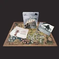 A boxed set titled "The One Ring: Starter Set" is prominently displayed, featuring artwork of a fantasy landscape with ruins and characters. Surrounding the box is a large, illustrated map depicting various locations, alongside several sheets of paper, including one with text and an image of a character. Scattered across the map are numerous illustrated cardboard figures and eight custom dice, enhancing the tabletop gaming experience.