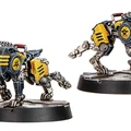 Two robotic canines, known as Hardcase Cyber-Mastiffs, are depicted in the image. They feature a sleek, metallic design with a dark blue body, accented by yellow details and mechanical joints. Each dog stands on a circular base, showcasing their imposing presence, with one positioned in a more dynamic stance while the other appears slightly more stationary.