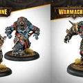 Two detailed miniatures from the Khador Old Umbrey Auxiliary Expansion for Warmachine are showcased. On the left, a large, muscular figure with blue skin and a fierce bear-like appearance, adorned with red markings and tribal accessories, stands ready for battle. On the right, another imposing figure, similarly styled with a rugged look and equipped with armor and weapons, exudes a menacing presence. Both figures are mounted on circular bases with tufts of grass, emphasizing their wild and savage nature.