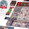 A tabletop game setup features a detailed game board depicting Paris, with various pathways and locations marked. Red and green player pieces are scattered across the board, alongside dice in red and black. Several decks of cards are arranged at the bottom, showcasing character artwork, while a box labeled "PLATYPUS GAME" is positioned in the upper left corner. The game emphasizes its asymmetric nature, allowing players to choose between the Nazi occupiers and the French Resistance.