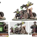 A detailed model of a war machine from the Zharrdron army, featuring a large, imposing structure with a prominent cannon mounted on top. The cannon is adorned with green, glowing elements and is flanked by two armored figures in dark, ornate attire, one of whom is operating the weapon. The base of the model includes intricate mechanical details and a textured surface, enhancing its industrial aesthetic.