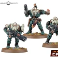 Three miniature figures from the Leagues of Votann are displayed on a grassy base. The central figure, slightly taller, is equipped with a pistol and has a distinctive armor design featuring green and beige colors, along with a decorative belt. The two flanking figures are shorter, one holding a large futuristic weapon, while the other has a more relaxed stance with a hand raised, possibly gesturing. All three figures exhibit a robust, armored appearance typical of the faction's aesthetic.