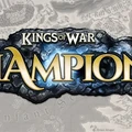 The logo for "Kings of War: Champions" features bold, stylized text with "KINGS OF WAR" in gold above "CHAMPIONS," which is highlighted in a bright blue against a textured black stone background. The design conveys a sense of fantasy and adventure, suitable for a tabletop gaming theme. The backdrop includes a faint map-like texture, suggesting a rich game world.