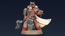 Aster Crohne, a new miniature from Games Workshop, is depicted as a Blood Angels veteran. He wears ornate red armor adorned with gold details and intricate patterns, complemented by a flowing white cape. In one hand, he wields a large, menacing weapon, while his other hand is outstretched, suggesting a commanding presence. The base features a sandy texture, enhancing the overall dynamic of the figure against a dark background.