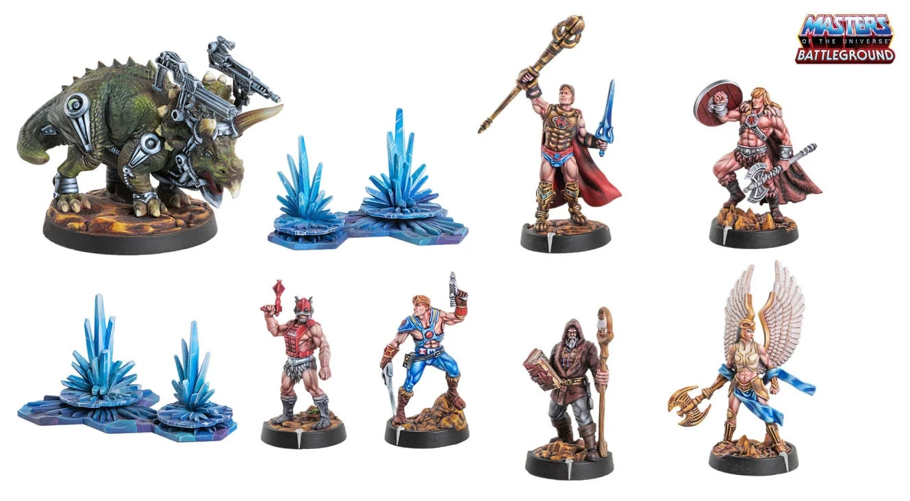 A collection of miniature figures from the Masters of the Universe: Battleground game features several characters, including a muscular hero wielding a sword and staff, a warrior with a shield and axe, and a figure with wings holding a weapon. In the background, there are two pieces of terrain: a blue and purple crystalline structure and a rocky base. The characters are intricately detailed, showcasing vibrant colors and dynamic poses, set against a clean white backdrop.