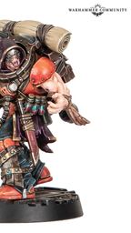 A muscular character from Necromunda stands confidently, wielding a large weapon in one hand. He wears a mix of dark and vibrant armor, featuring orange and black accents, and has a large backpack with rolled-up materials. His fierce expression and detailed gear, including various pouches and a utility belt, emphasize his menacing presence.