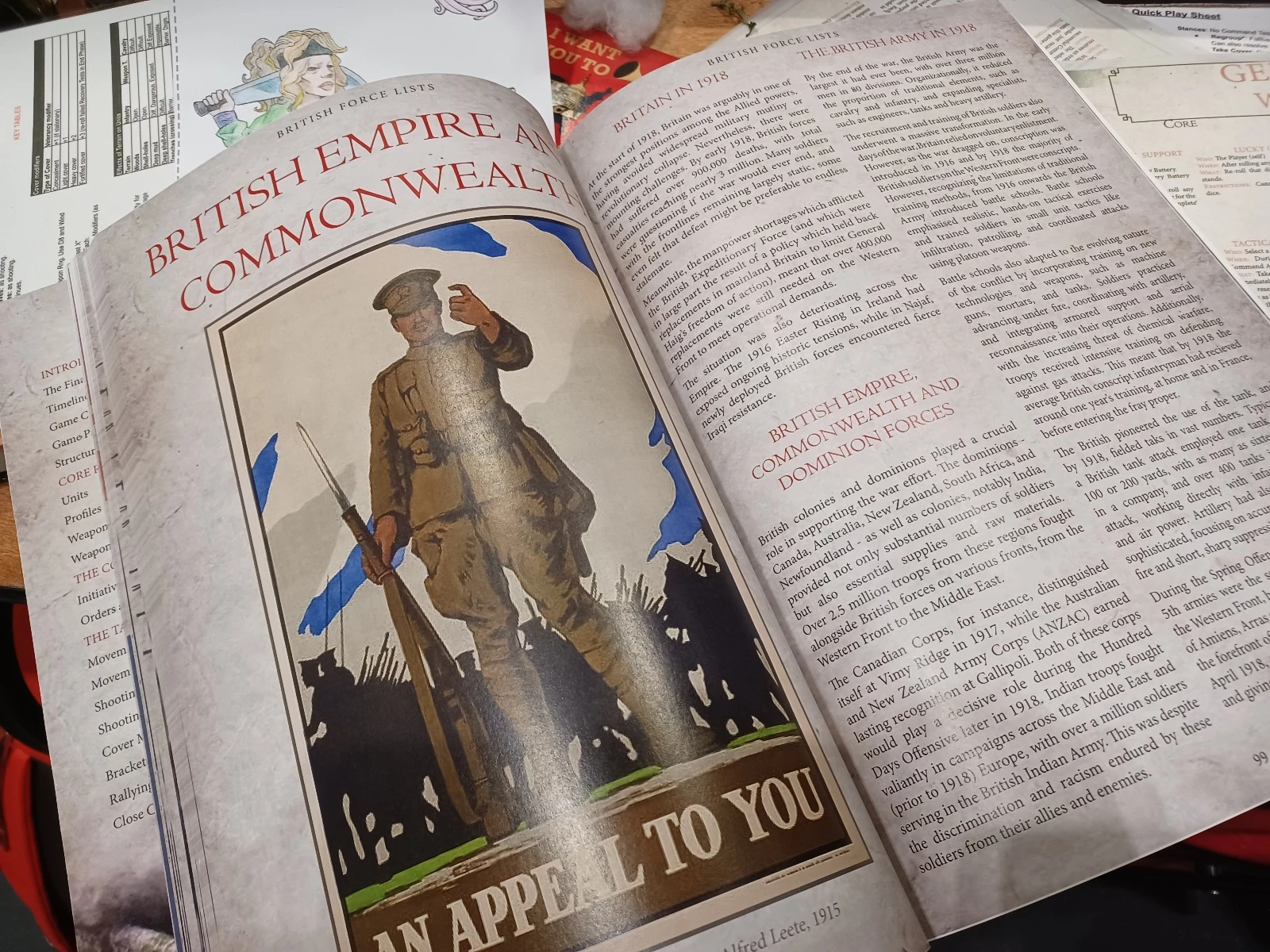 A close-up view of an open book page featuring a vintage recruitment poster from 1915, depicting a soldier in uniform holding a rifle, with the text "AN APPEAL TO YOU" at the bottom. The background includes blue and white elements, suggesting a patriotic theme. The adjacent page contains text discussing the British Army in 1918, detailing the contributions of Commonwealth and Dominion forces during World War I.