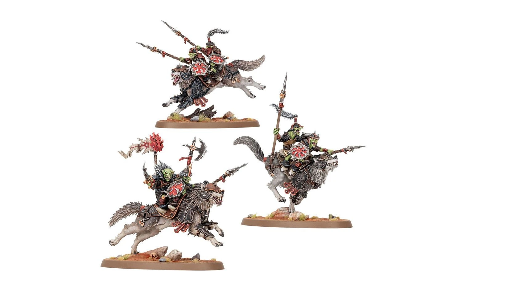 Three goblin miniatures are depicted riding wolves, each showcasing unique poses and details. The goblins are adorned in armor with red and silver accents, wielding spears and axes, while their wolves are intricately designed with fur textures and harnesses. The bases feature a rocky terrain with small skulls and tufts of grass, enhancing the dynamic and fierce appearance of the scene.