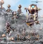 A group of intricately designed Kharadron Overlords miniatures is displayed on a rocky terrain, showcasing their steampunk aesthetic. The figures, featuring metallic colors of bronze and gold, include various duardin in nullsuits, armed with cutlasses and pistols, alongside a dirigible airship hovering above. Crystals and rocky formations add depth to the scene, enhancing the adventurous theme of these flying dwarves.