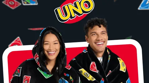 Two people in UNO-themed hooded blankets, with UNO logo and cards in background. Text: "Game night sorted"