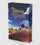 Boxed board game cover titled "Through the Desert" in gold foil lettering. A desert scene with three camels carrying riders on a dune, palm trees in the distance, and a starry night sky.