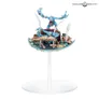 Miniature of a blue-skinned Greater Daemon of Tzeentch standing on a circular base, holding a staff, with a small creature kneeling beside an open book and scattered scrolls.