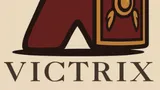A stylized logo features a red game piece resembling a Roman soldier, complete with a golden helmet and a shield adorned with a decorative emblem. Below the figure, the word "VICTRIX" is displayed in bold, dark lettering. The background is a light beige color, enhancing the logo's vibrant elements.