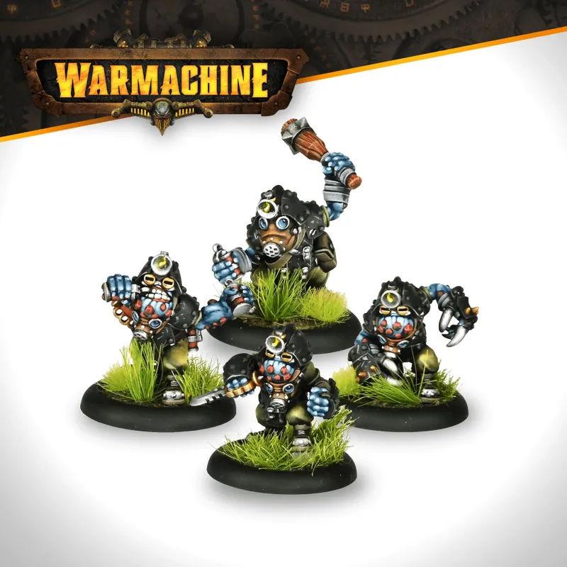 A group of four trollkin figures from the Southern Kriels Kithguard army for Warmachine, each standing on round black bases adorned with tufts of green grass. The figures are dressed in rugged, dark clothing with mechanical elements, featuring distinctive masks and goggles. One figure is raising a weapon, while the others are posed in various stances, showcasing their unique designs and expressions.