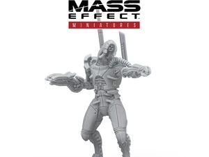 A detailed gray resin miniature from the Mass Effect universe stands on a circular black base, depicting a humanoid figure with a sleek, armored design. The figure features intricate mechanical details, including visible joints and a raised arm holding a weapon, suggesting a combat-ready stance. The Mass Effect logo is prominently displayed at the top, along with the Modiphius Entertainment branding at the bottom.