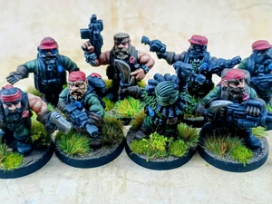 A group of eight intricately detailed miniatures representing space dwarves in a jungle setting, each standing on circular bases adorned with tufts of grass. The figures are dressed in military-style attire, featuring green clothing and red caps, with various weapons including guns and a curved blade. Their expressions are fierce and determined, showcasing a blend of ruggedness and character typical of old-school metal miniatures.