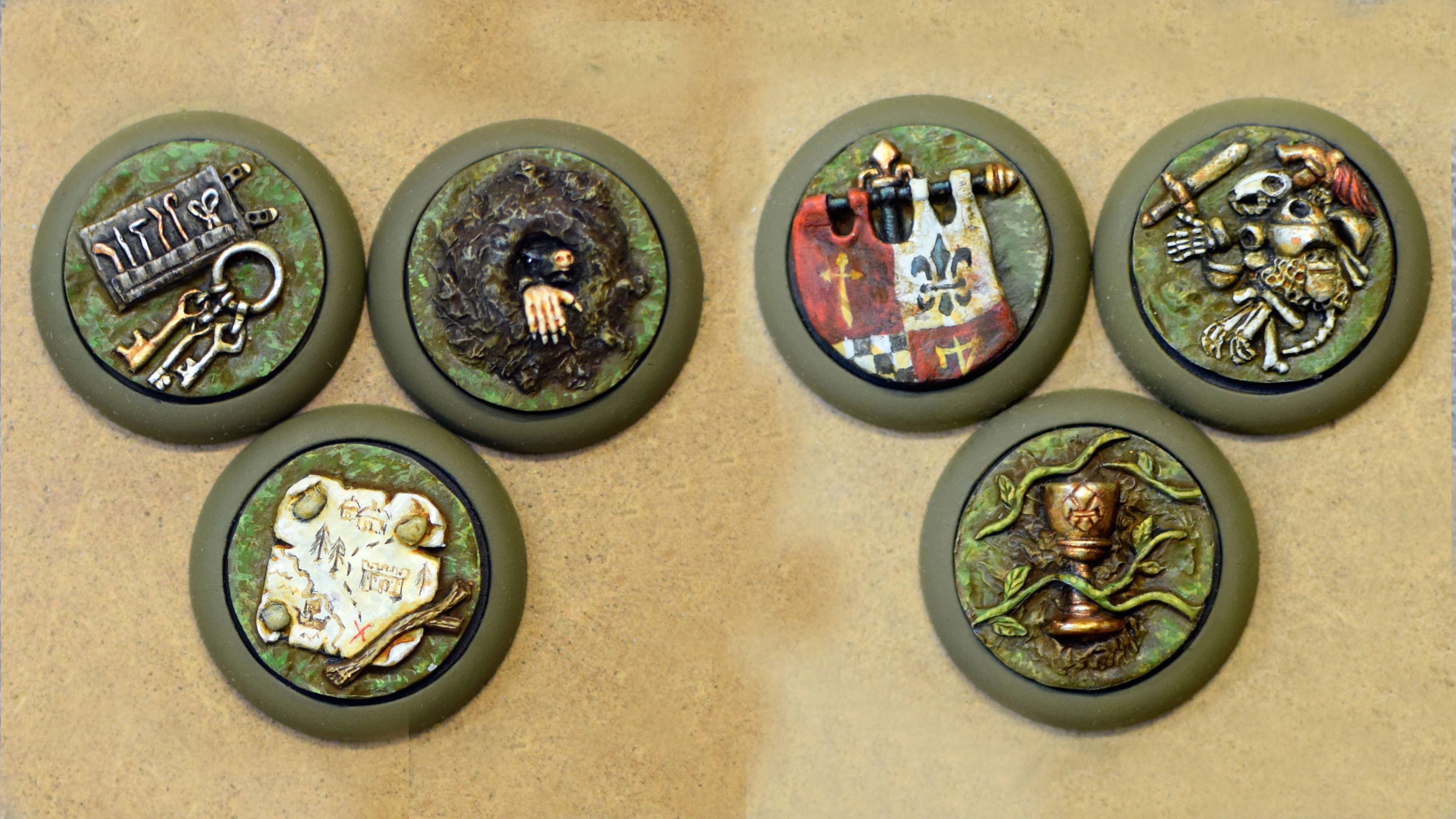 Four objective markers are displayed on a textured surface. Each marker features a distinct design: one shows a collection of tools, another depicts a hand emerging from a burrow, a third features a map with a castle and trees, and the last displays a shield with a checkered pattern. The markers are set against a green, grassy background, enhancing their thematic connection to the Burrows and Badgers game.