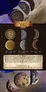 Three round metal coins: one full moon with craters, one half moon, one crescent moon. Diameters labeled 28 mm, 15.5 mm, 15.5 mm. Text reads: "Like the moon itself, this set is beautiful and mysterious... Suitable for games like: Lords of Waterdeep, D&D, Luna, Terraforming Mars."