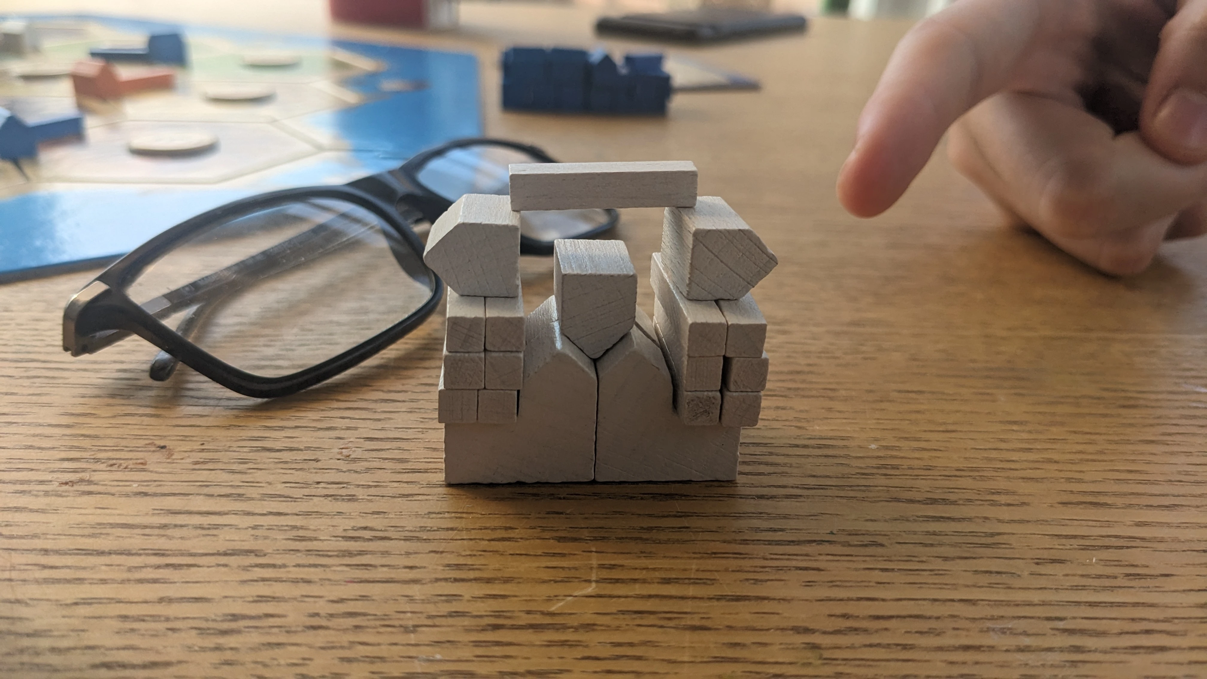 The Catan pieces stacked up in a way to look a tiny bit like a tiny citadel