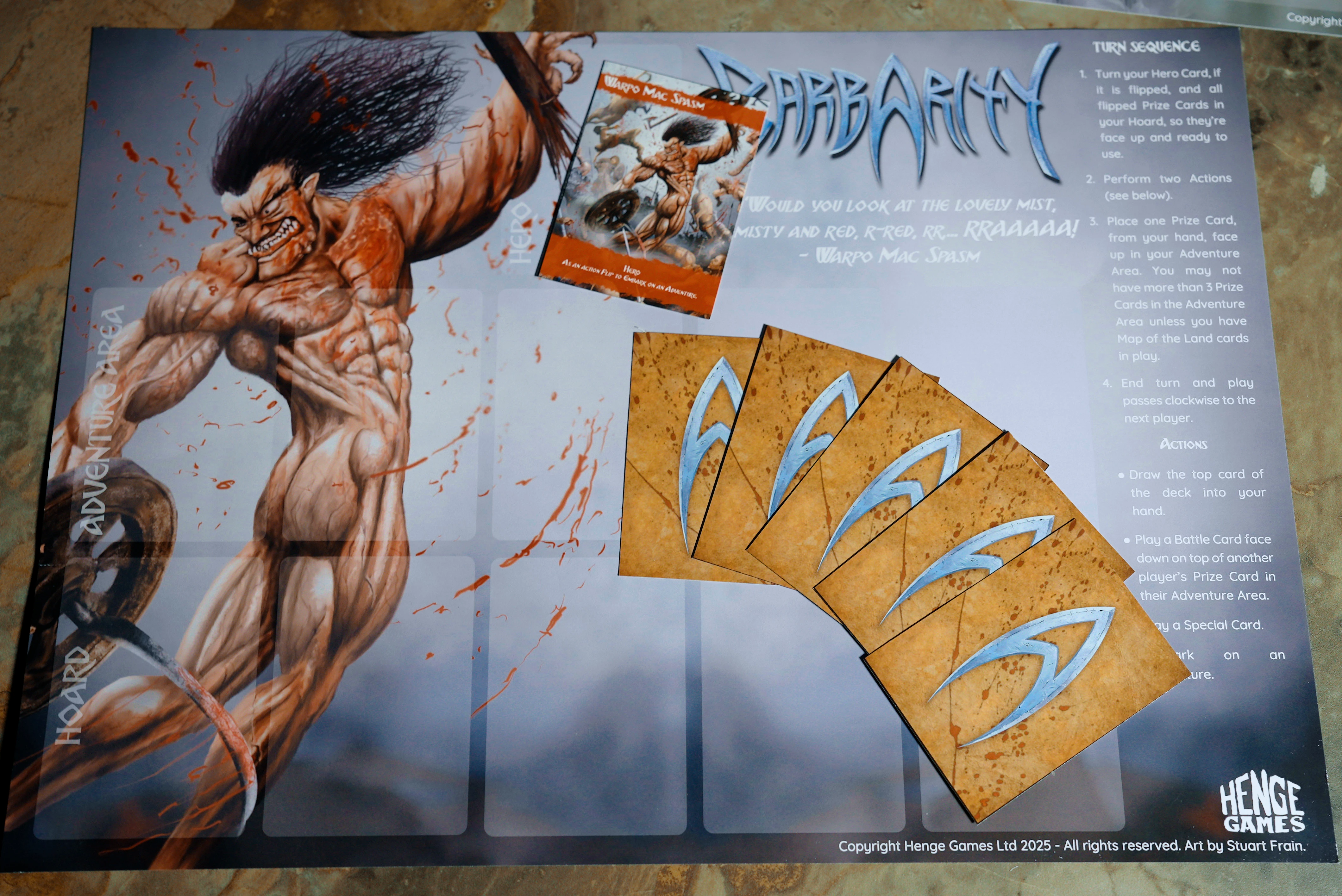 The image features a game board for the card game "Barbarity," prominently displaying a muscular barbarian character with long, wild hair and a fierce expression, depicted in a dynamic pose. The background is splattered with red, suggesting a violent theme. To the right, there are several game cards, including one labeled "Warpo Mac Spasm," alongside a set of prize cards that have a textured, brown appearance with stylized blue markings. The board has designated areas for adventure cards, emphasizing the game's focus on combat and resource management.
