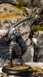 A detailed miniature scene features a character with large, intricately designed black wings, dressed in a mix of armor and clothing, wielding a weapon and casting a spell. Opposite this character stands a massive, armored figure with glowing green accents and a spiked weapon, set against a rocky terrain with patches of moss. The contrasting sizes and designs of the two figures highlight the dynamic nature of the scene.