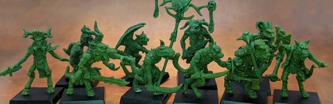 A collection of old school miniatures from Satyr Art Studio, featuring various fantastical creatures in a vibrant green color. The figures include beastmen with distinct features such as horns and claws, some wielding weapons, and a central figure holding a staff topped with a skull and a crescent. They are displayed on black bases against a warm, textured background.