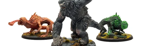 The image features three miniatures from Modiphius’ Fallout: Wasteland Warfare line. On the left is a snallygaster, a hexapod creature with a reddish-brown body, multiple eyes on its back, and a long, protruding tongue. In the center stands a large, muscular megasloth, covered in gray fur, with a menacing pose and a raised arm. To the right is another creature, possibly a variant of the snallygaster, in green, with a textured body and large eyes, all set on circular bases adorned with tufts of grass.