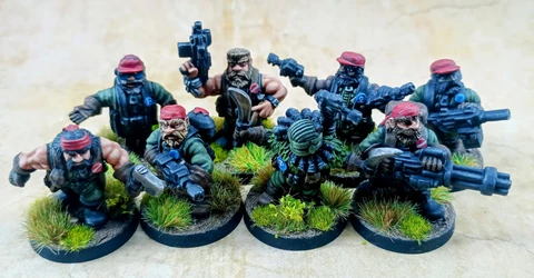 A group of eight intricately detailed miniatures representing space dwarves in a jungle setting, each standing on circular bases adorned with tufts of grass. The figures are dressed in military-style attire, featuring green clothing and red caps, with various weapons including guns and a curved blade. Their expressions are fierce and determined, showcasing a blend of ruggedness and character typical of old-school metal miniatures.
