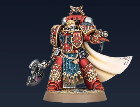 Aster Crohne, a new miniature from Games Workshop, is depicted as a Blood Angels veteran. He wears ornate red armor adorned with gold details and intricate patterns, complemented by a flowing white cape. In one hand, he wields a large, menacing weapon, while his other hand is outstretched, suggesting a commanding presence. The base features a sandy texture, enhancing the overall dynamic of the figure against a dark background.